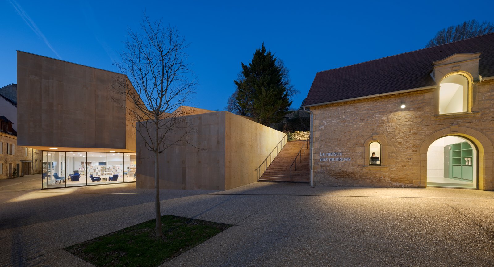 Médiathèque de Sarlat-la-Canéda — façade de nuit, architecture contemporaine en béton ocre